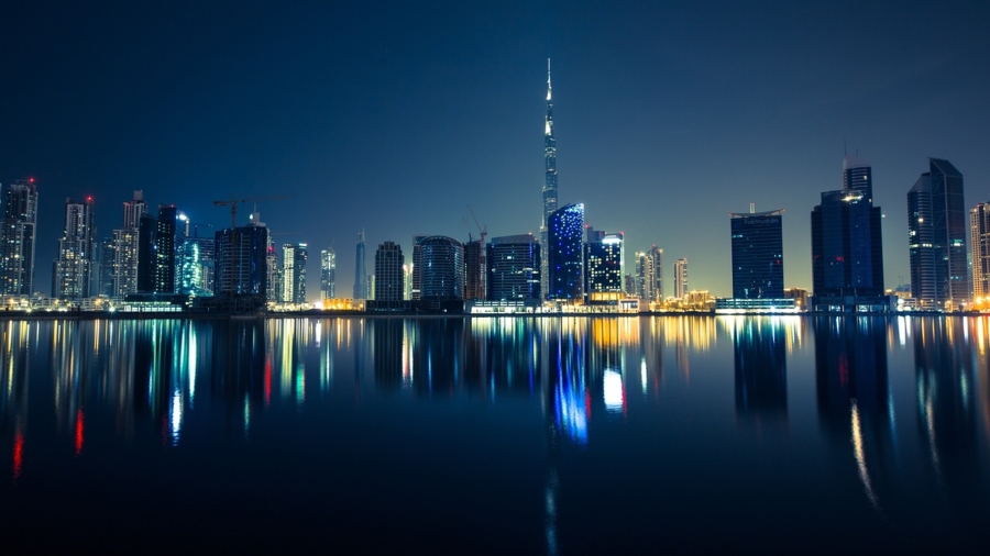 A stunning night photography of a cityscape with bright lights and a clear starry sky.