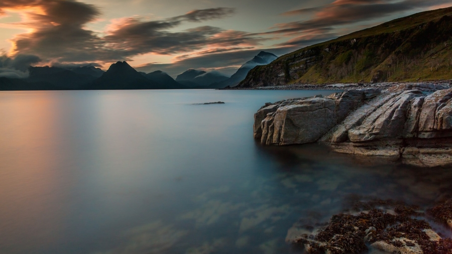 Beautiful sunset over a tranquil lake with mountains in the background, showcasing nature photography