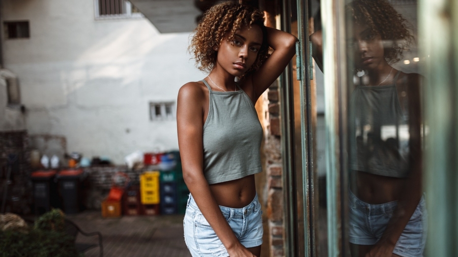 A stylish individual posing in an urban setting for a street fashion photography shoot